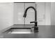 Close up image of a kitchen sink with a dark countertop and pull down faucet in a modern kitchen at 2736 Victory Dr, Columbus, IN 47203