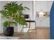 Cozy kitchen scene with live plants and a bar stool in front of bright white cabinets and hardwood floors at 2736 Victory Dr, Columbus, IN 47203