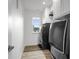 Efficient laundry room with modern washer and dryer, storage cabinets, and wood-look flooring at 2736 Victory Dr, Columbus, IN 47203