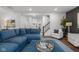 Open concept living room featuring a large blue sectional, hardwood floors, and staircase at 2736 Victory Dr, Columbus, IN 47203