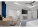 A primary bedroom features a tray ceiling, sitting chair, mounted TV, and ensuite bathroom at 2736 Victory Dr, Columbus, IN 47203
