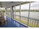 Enclosed sunroom with wood furnishings features a waterfront view and plenty of natural light at 3004 Lake Shore Dr # E, Indianapolis, IN 46205