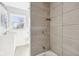 Modern bathroom featuring new shower with tile surround and view of vanity and window at 422 N Oxford St, Indianapolis, IN 46201