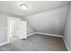 A grey bedroom featuring neutral walls, gray carpeting, with an open door at 422 N Oxford St, Indianapolis, IN 46201