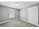 A bright bedroom featuring neutral walls, grey carpeting, and a window with blinds at 422 N Oxford St, Indianapolis, IN 46201