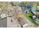 Aerial view featuring a two-story house with a detached garage, a gravel parking area, and mature trees at 422 N Oxford St, Indianapolis, IN 46201