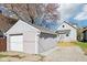 Detached one-car garage with white door next to home with fresh gravel driveway at 422 N Oxford St, Indianapolis, IN 46201