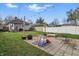 View of a lawn in a backyard with a patio, string lights and play equipment at 4815 Winthrop Ave, Indianapolis, IN 46205