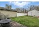 View of a lawn in a backyard with a concrete patio, a fence and sheds at 4815 Winthrop Ave, Indianapolis, IN 46205