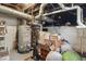 A view of a messy unfinished basement with a hot water heater and water pipes at 4815 Winthrop Ave, Indianapolis, IN 46205