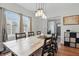Bright dining room boasts a wooden table, elegant lighting, and natural light from large windows at 4815 Winthrop Ave, Indianapolis, IN 46205