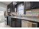 Modern kitchen featuring dark cabinetry, stainless steel appliances, and subway tile backsplash at 4815 Winthrop Ave, Indianapolis, IN 46205
