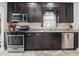Well-equipped kitchen with stainless steel appliances, granite countertops, and dark cabinets at 4815 Winthrop Ave, Indianapolis, IN 46205