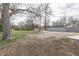 Large backyard area with mature trees, gravel, and partial fence at 4945 Camden St, Indianapolis, IN 46227