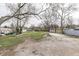 Backyard featuring grass, trees, gravel, and concrete patio area at 4945 Camden St, Indianapolis, IN 46227