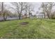 Large backyard area with mature trees and gravel at 4945 Camden St, Indianapolis, IN 46227