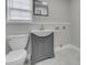 Bathroom featuring modern gray vanity and toilet next to a square mirror at 4945 Camden St, Indianapolis, IN 46227