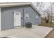Exterior view of house showing grey vinyl siding and small concrete patio area at 4945 Camden St, Indianapolis, IN 46227