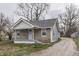 Delightful stone and siding home with a well-maintained gravel driveway and quaint front porch at 4945 Camden St, Indianapolis, IN 46227