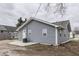 View of the home's gray vinyl siding and a concrete patio area at 4945 Camden St, Indianapolis, IN 46227