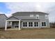 View of the rear elevation showing a covered patio with gray siding and multiple windows at 4952 Cinnabar Trl, Brownsburg, IN 46112