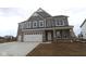Newly built two-story home showcasing a three-car garage and stone and siding exterior at 4952 Cinnabar Trl, Brownsburg, IN 46112