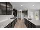 Modern kitchen with stainless steel appliances, dark wood cabinets, a white countertop, and an island at 4960 Cinnabar Trl, Brownsburg, IN 46112