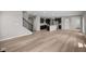 Open-concept living space with hardwood flooring, seamless access to the kitchen, and a staircase at 4960 Cinnabar Trl, Brownsburg, IN 46112