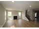 Bright living room featuring a fireplace, large windows, and hardwood floors and black staircase at 4960 Cinnabar Trl, Brownsburg, IN 46112