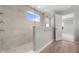 A stunning walk-in shower featuring beige tile and a seamless glass enclosure at 4960 Cinnabar Trl, Brownsburg, IN 46112