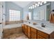 Bright bathroom with double vanity, soaking tub, and a large window for natural light at 5312 Ripplingbrook Way, Carmel, IN 46033