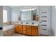 Bright bathroom with double vanity, soaking tub, and a large mirror reflecting natural light at 5312 Ripplingbrook Way, Carmel, IN 46033