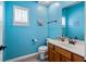 Bright powder room features blue walls, wood-look flooring, and traditional fixtures at 5312 Ripplingbrook Way, Carmel, IN 46033