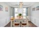 Dining room with tray ceiling, hardwood floors, curtains, modern chandelier, and table set for six at 5312 Ripplingbrook Way, Carmel, IN 46033