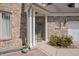 Close-up of the brick front door and covered porch with white columns at 5312 Ripplingbrook Way, Carmel, IN 46033