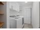 Neat laundry room with modern washer and dryer, overhead cabinets, and tiled floors at 5312 Ripplingbrook Way, Carmel, IN 46033
