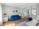 Bright living room featuring hardwood floors, a blue velvet sofa, and an open layout to the dining area at 5312 Ripplingbrook Way, Carmel, IN 46033