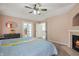 Serene main bedroom features a fireplace, a ceiling fan, and an ensuite bathroom with walk-in closet at 5312 Ripplingbrook Way, Carmel, IN 46033