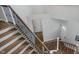 Elegant staircase featuring hardwood steps, rod iron railings, and a bright, open entryway at 5312 Ripplingbrook Way, Carmel, IN 46033