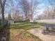 Large backyard featuring a fire pit, table with seating, and wood privacy fence at 5512 Straw Hat Dr, Indianapolis, IN 46237