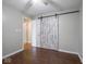 This bedroom has hardwood floors and a rustic sliding door at 5512 Straw Hat Dr, Indianapolis, IN 46237