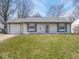 Well-kept single-story home featuring a tidy lawn, attached garage and charming light blue shutters at 5512 Straw Hat Dr, Indianapolis, IN 46237