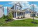Beautiful blue home featuring a cozy front porch and well-manicured lawn at 622 Ehrlich Ln, Westfield, IN 46074