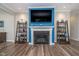 Living room with fireplace and television mounted over mantel with wood floors at 622 Ehrlich Ln, Westfield, IN 46074