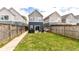 A fenced backyard has a grassy lawn, patio furniture, a barbecue, and a walkway at 64 Central Greens Blvd, Indianapolis, IN 46222