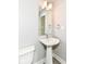 Clean pedestal sink bathroom with gray walls, wood floor, mirror, and updated fixtures at 64 Central Greens Blvd, Indianapolis, IN 46222