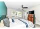 Bedroom with dark accent wall, ceiling fan, window with blinds, TV on dresser, and carpeted floors at 64 Central Greens Blvd, Indianapolis, IN 46222