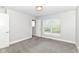 This bedroom features neutral gray walls, carpet, a window with blinds, and an ensuite door at 64 Central Greens Blvd, Indianapolis, IN 46222