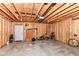 The garage is spacious and unfinished with exposed wood and various tools and yard care items at 64 Central Greens Blvd, Indianapolis, IN 46222