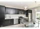 Modern kitchen features dark cabinetry, stainless steel appliances, white subway tile backsplash, and stainless steel island at 64 Central Greens Blvd, Indianapolis, IN 46222